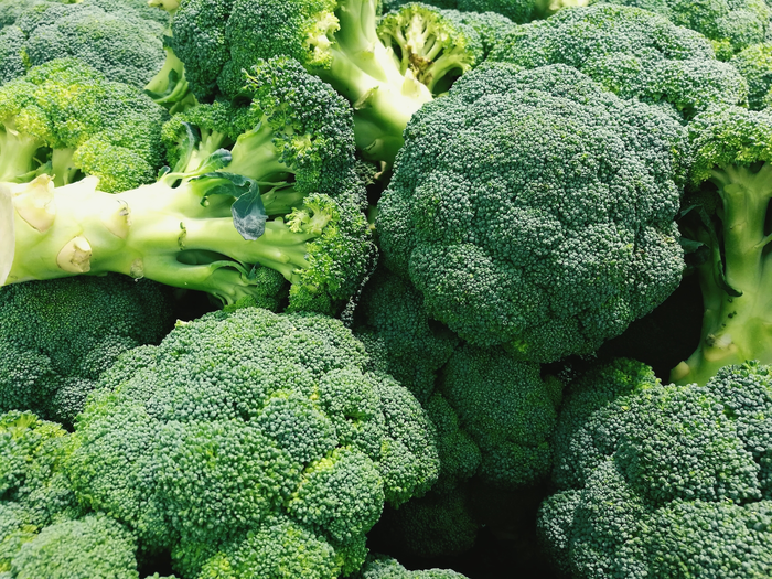 Fresh, vibrant broccoli heads stacked together, showcasing their rich green color and dense florets, ideal for healthy meals and nutritious recipes.